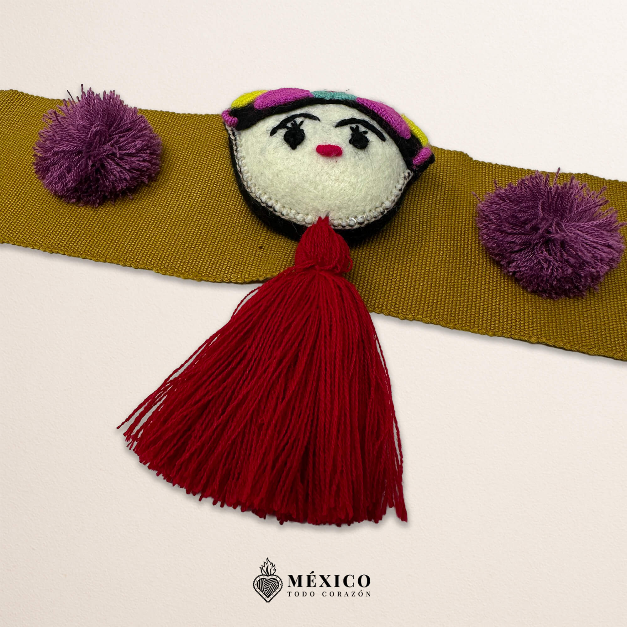 Beige artisan waist belt featuring a Mexican doll embellishment with multicolor pom-poms