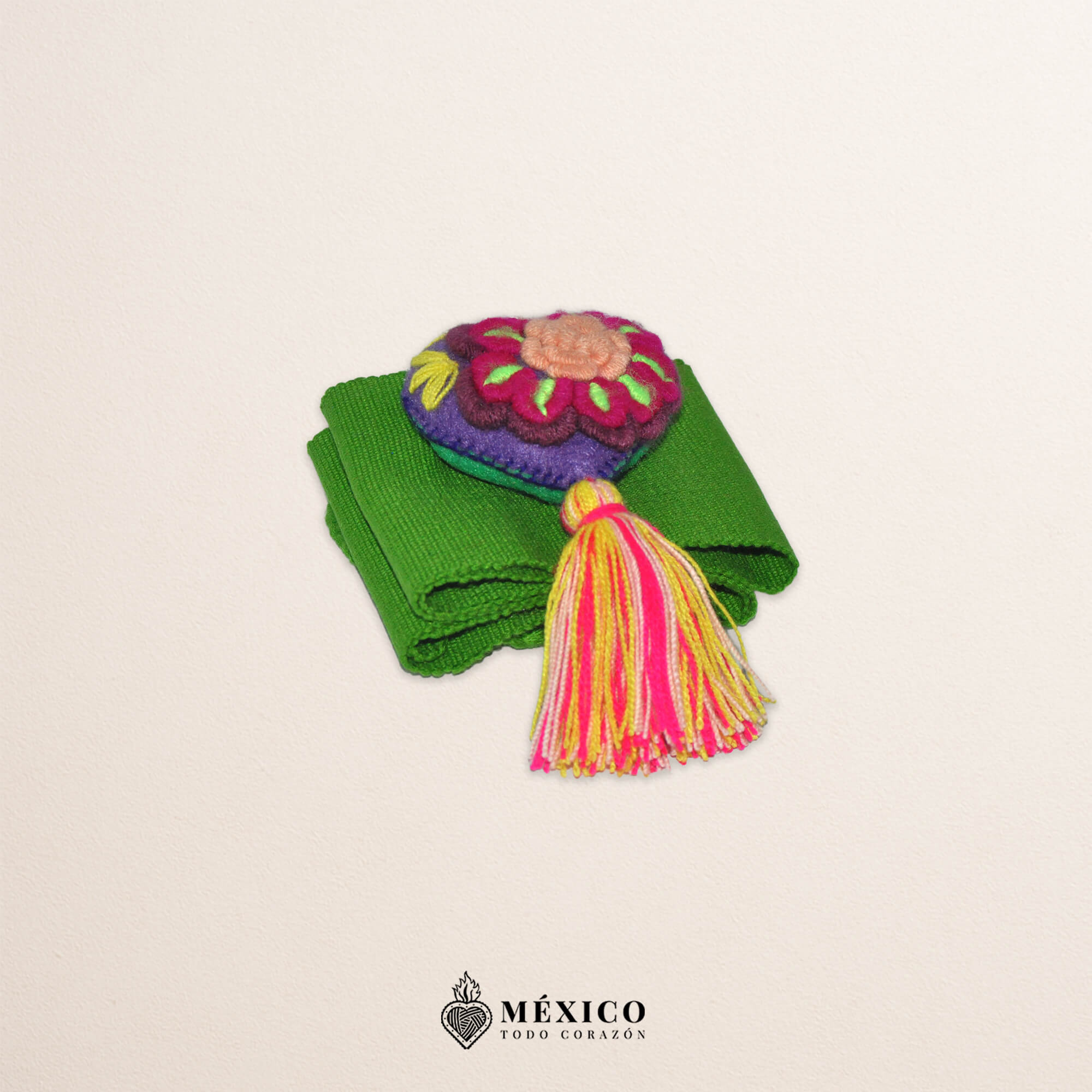 Green artisan Mexican waist belt featuring a floral heart embellishment in multicolor felt