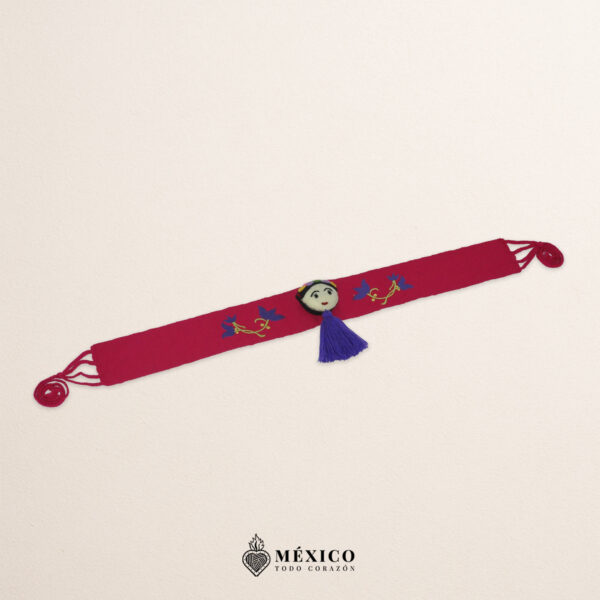 Fuchsia artisan waist belt featuring floral embroidery and a Mexican doll embellishment