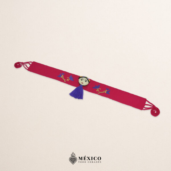 Fuchsia artisan waist belt featuring floral embroidery and a Mexican doll embellishment